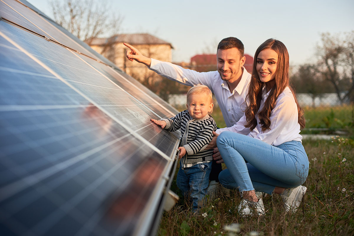 Rodina klečící u solárního panelu